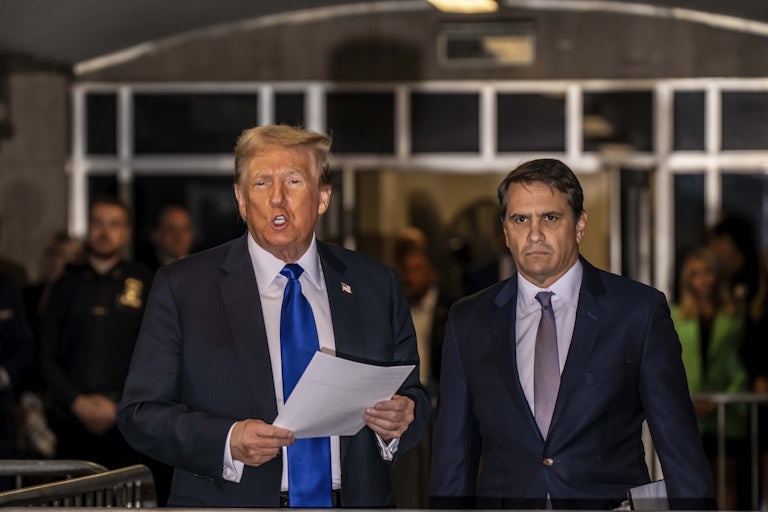 Todd Blanche stands next to Donald Trump while he speaks