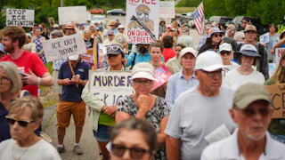 People protest with anti-ICE signs in the streets