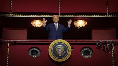Donald Trump holds his hands up while standing in the Presidential Box of the Opera House at the Kennedy Center