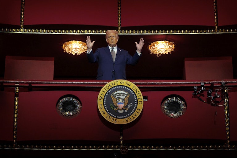 Donald Trump holds his hands up while standing in the Presidential Box of the Opera House at the Kennedy Center