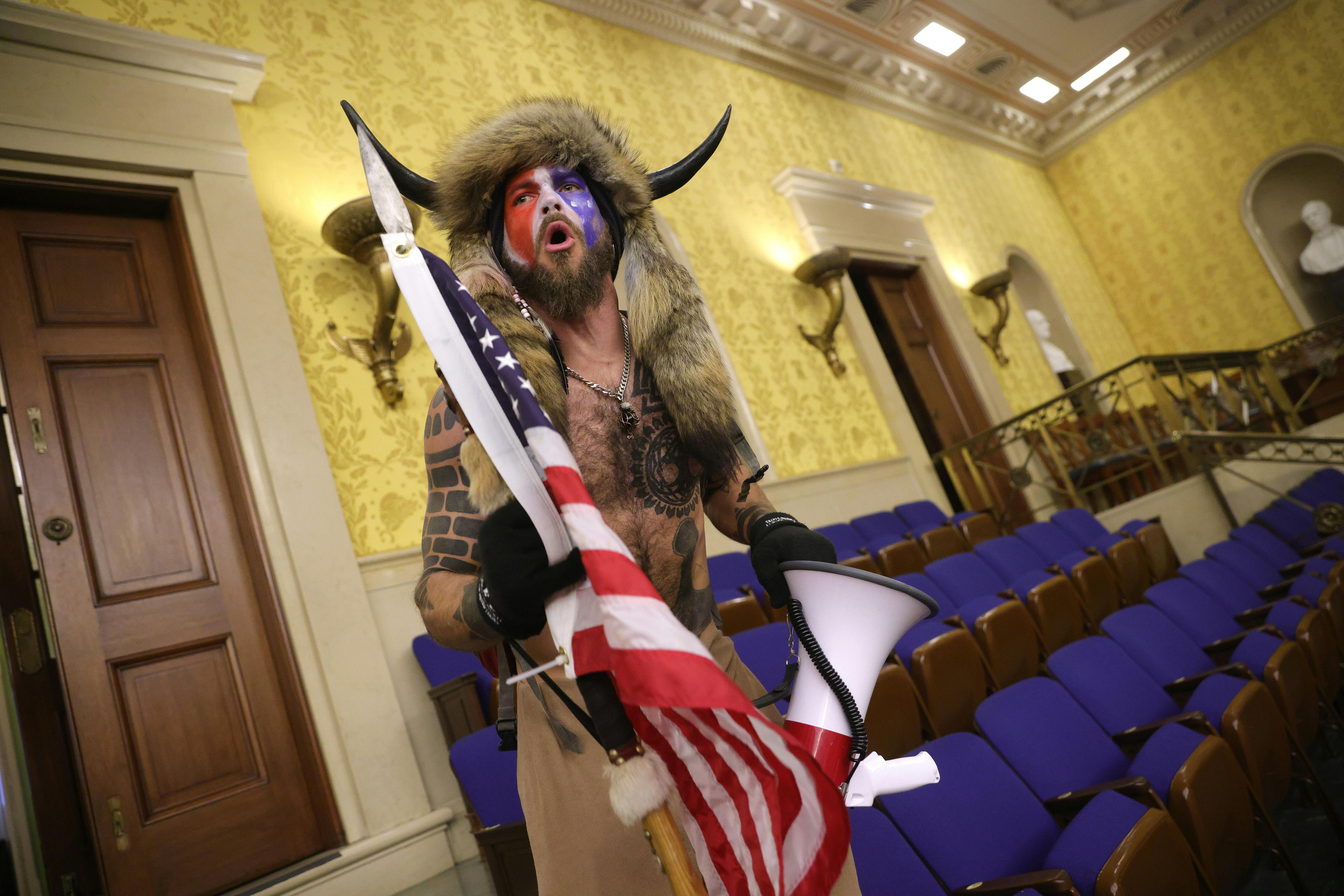Jacob Anthony Chansley screams "Freedom" inside the Senate chamber after the U.S. Capitol was breached by a mob during a joint session of Congress on January 06, 2021 in Washington, DC.