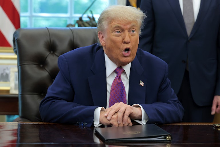 Donald Trump speaks while sitting at his desk in the Oval Office