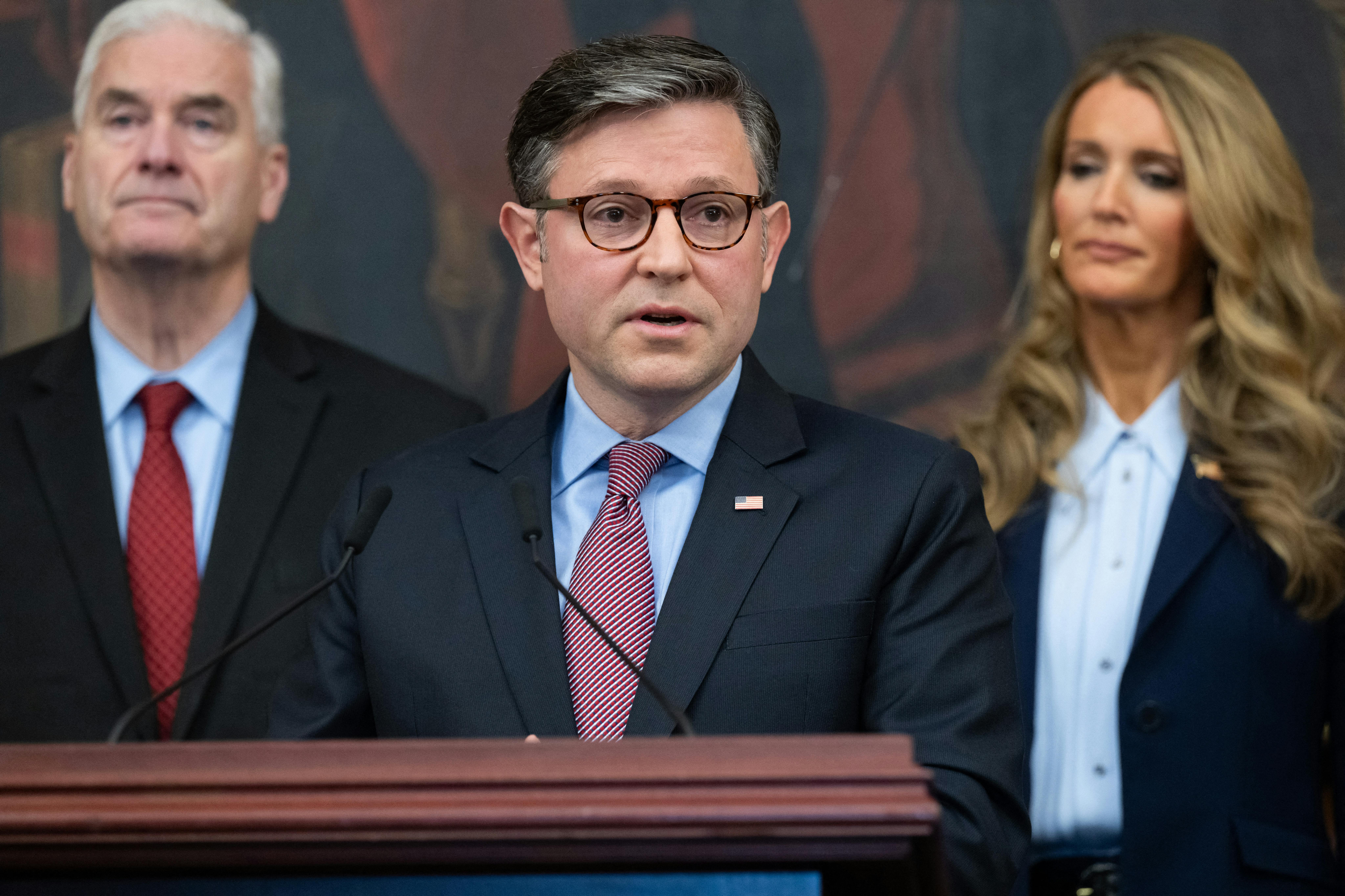 House Speaker Mike Johnson speaks in the Capitol. House Majority Whip Tom Emmer and SBA Administrator Kelly Loeffler are in the background.