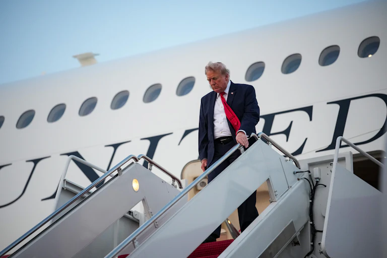 Donald Trump looks down while disembarking from Air Force One.