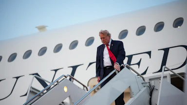 Donald Trump looks down while disembarking from Air Force One.