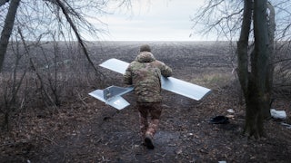 Volodymyr heads toward the field where he will launch the Darts drone.