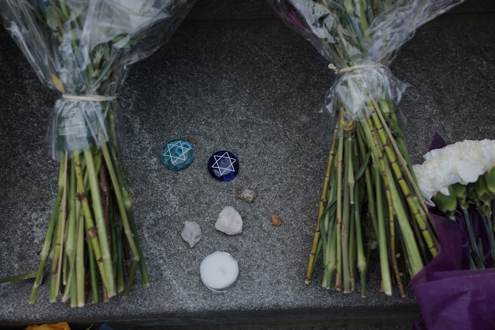 Handwritten notes, flowers and stones are left outside the Lillian and Albert Small Capital Jewish Museum on May 23, 2025 in Washington, D.C. A suspect, identified as Elias Rodriguez, has been arrested and charged with first-degree murder and other crimes for the killing of two Israeli Embassy staff members, Yaron Lischinsky and Sarah Lynn Milgrim outside of the Capital Jewish Museum.