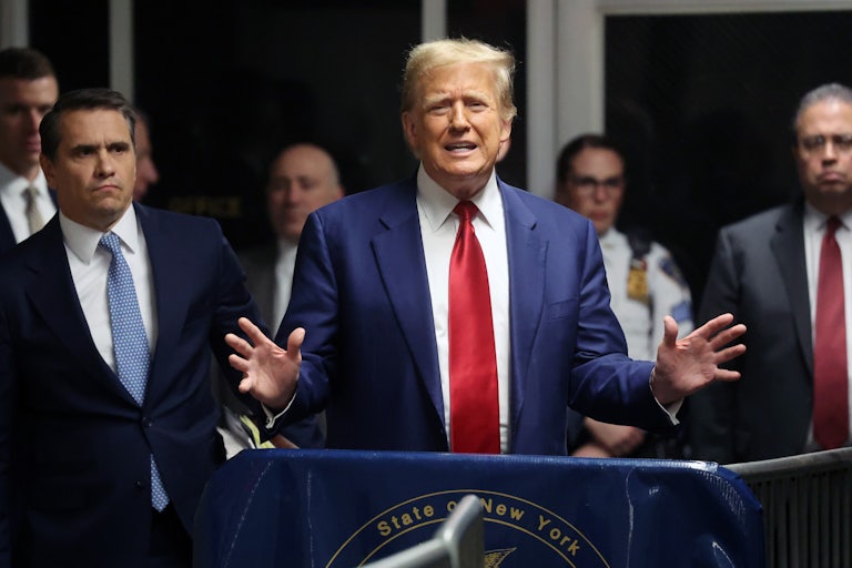Trump yells as his legal team surrounds him. A security guard is in the background.
