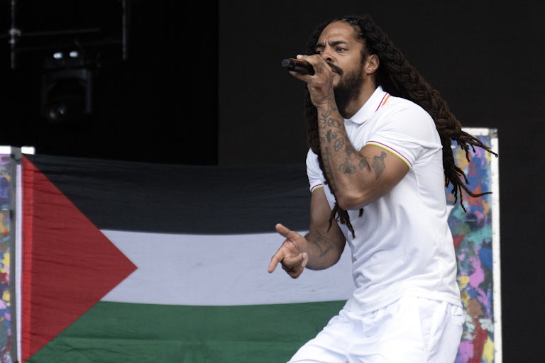 To the backdrop of a Palestinian flag, Bobby Vylan of British duo Bob Vylan performs on stage at the Glastonbury festival.