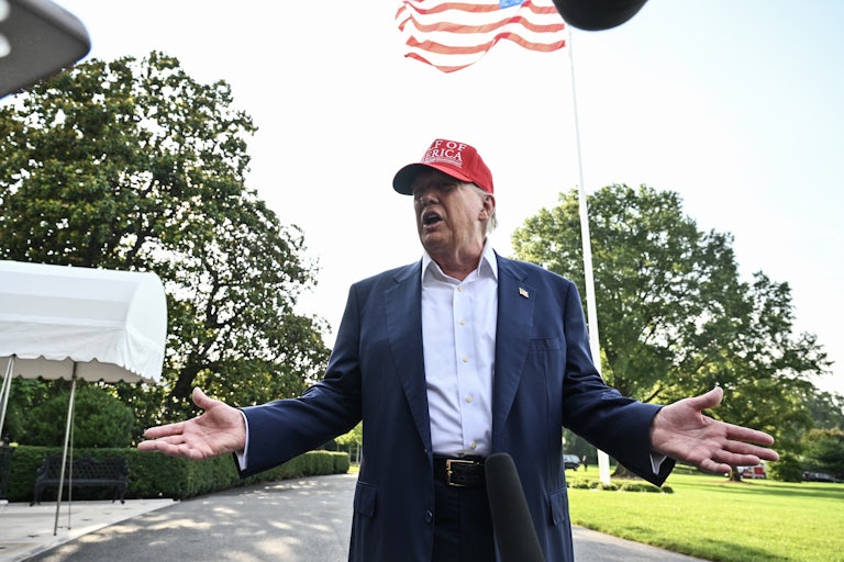Donald Trump holds his hands out to the side while speaking to reporters outside the White House