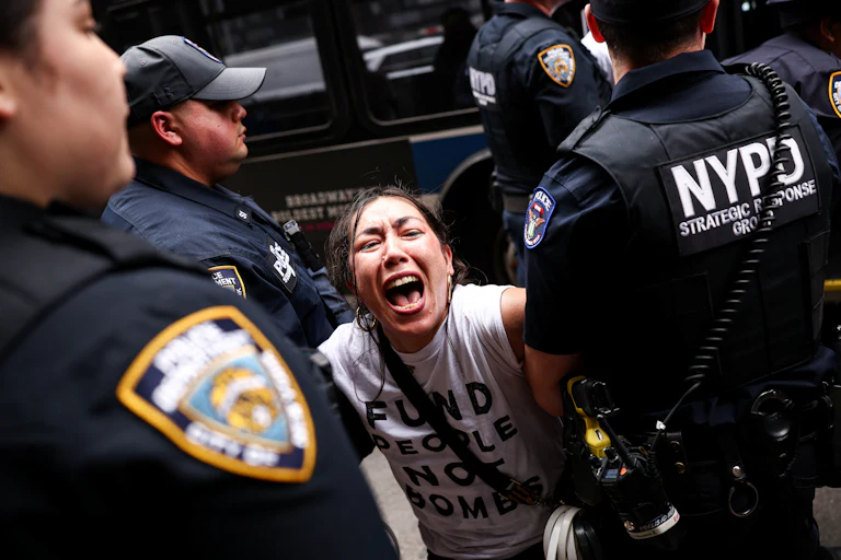 A woman screams as three police officers surround her.