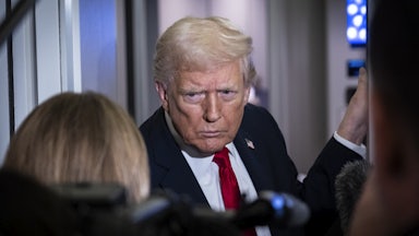 Donald Trump frowns while standing in front of reporters on Air Force One