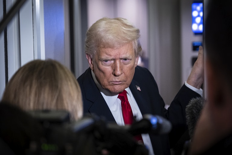 Donald Trump frowns while standing in front of reporters on Air Force One