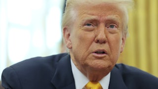 Donald Trump speaks and looks worried while sitting at his desk in the White House’s Oval Office.