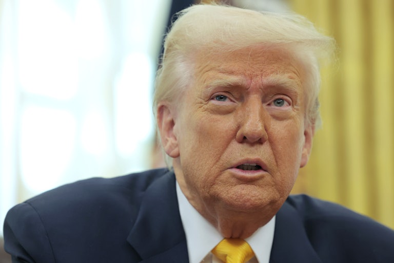 Donald Trump speaks and looks worried while sitting at his desk in the White House’s Oval Office.