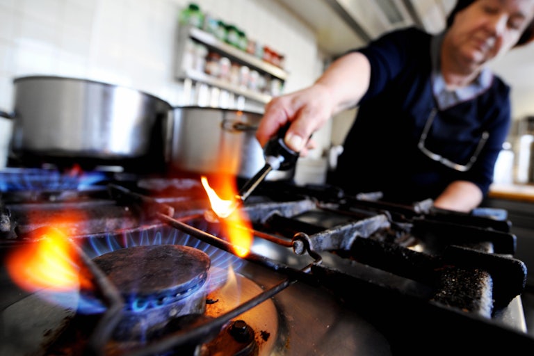 A person lights a gas stove.