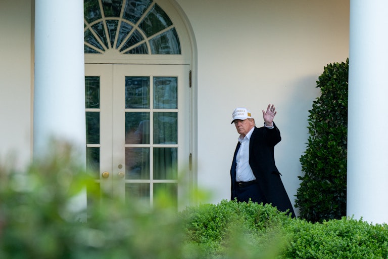 Donald Trump waves while walking into the White House