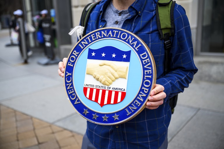 A person holds up the USAID seal