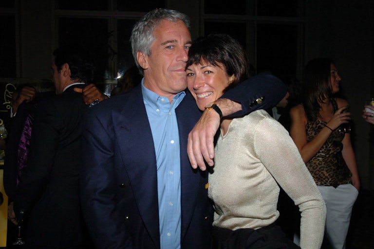 Jeffrey Epstein puts an arm around the shoulders of Ghislaine Maxwell and his mouth near her forehead.