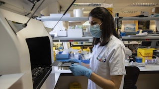 A laboratory technician holds samples for testing.