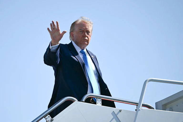 Donald Trump waves while boarding Air Force One