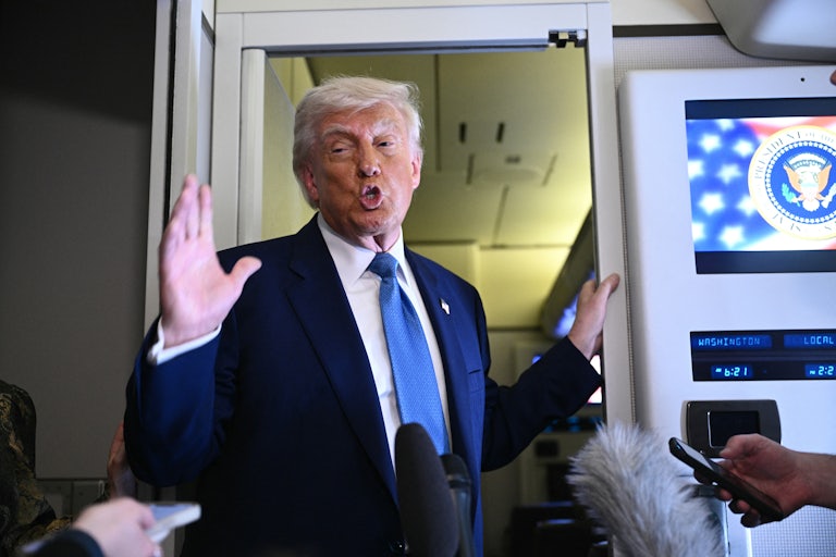Donald Trump gestures while speaking to reporters on Air Force One