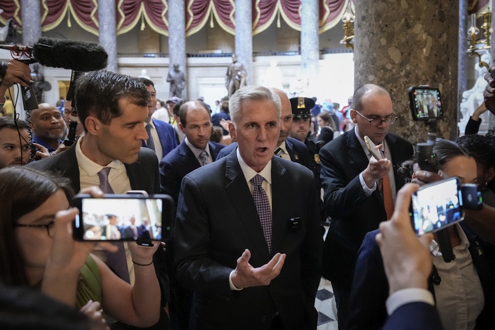 Kevin McCarthy talks while walking, surrounded by other people.