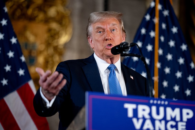 Donald Trump gestures while speaking at a podium