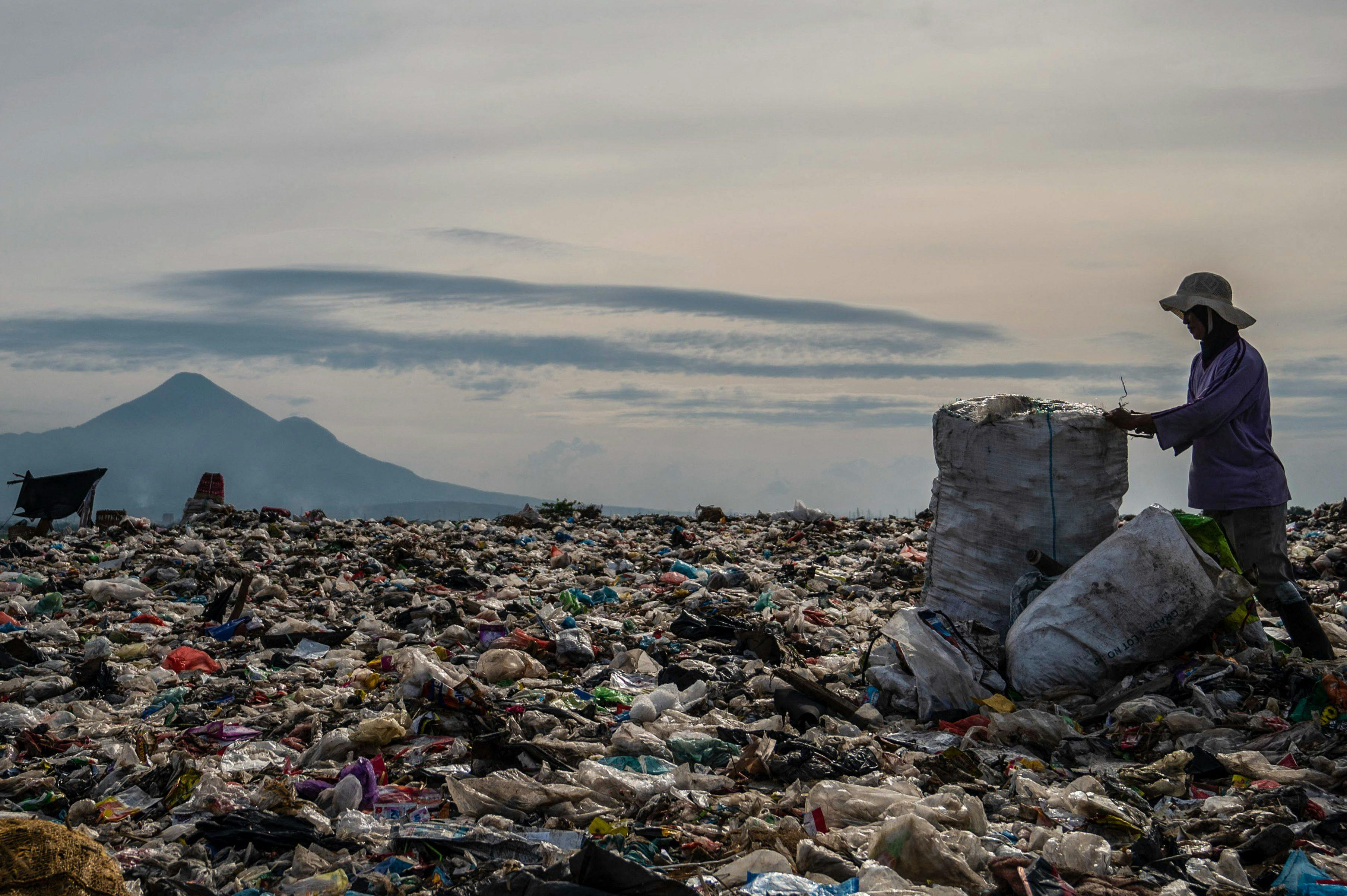 A ragpicker collects recyclable materials at a landfill in Sidoarjo, Indonesia, 2022