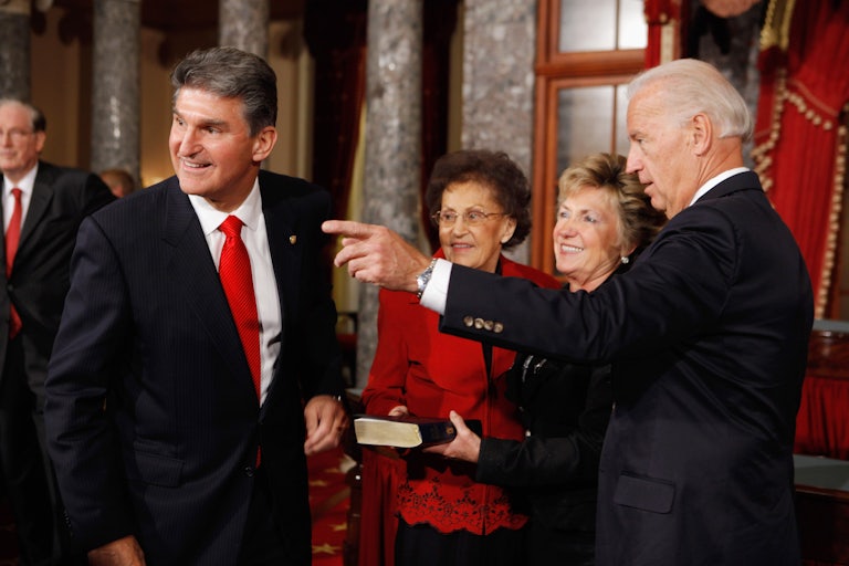Joe Biden gestures alongside Senator Joe Manchin.