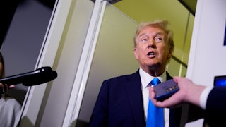 Donald Trump speaks with reporters aboard Air Force One.