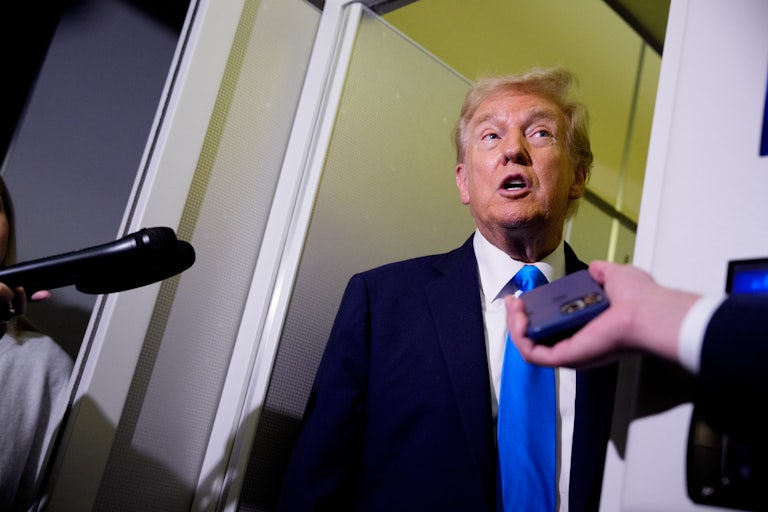Donald Trump speaks with reporters aboard Air Force One.