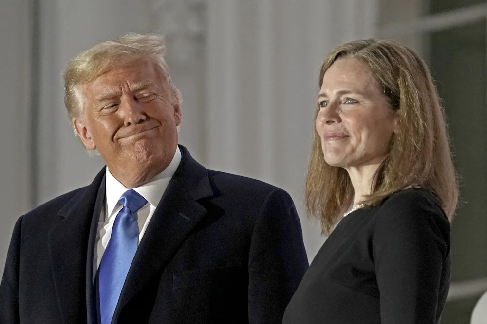 Donald Trump and Amy Coney Barrett stand on a balcony during a ceremony on the South Lawn of the White House.