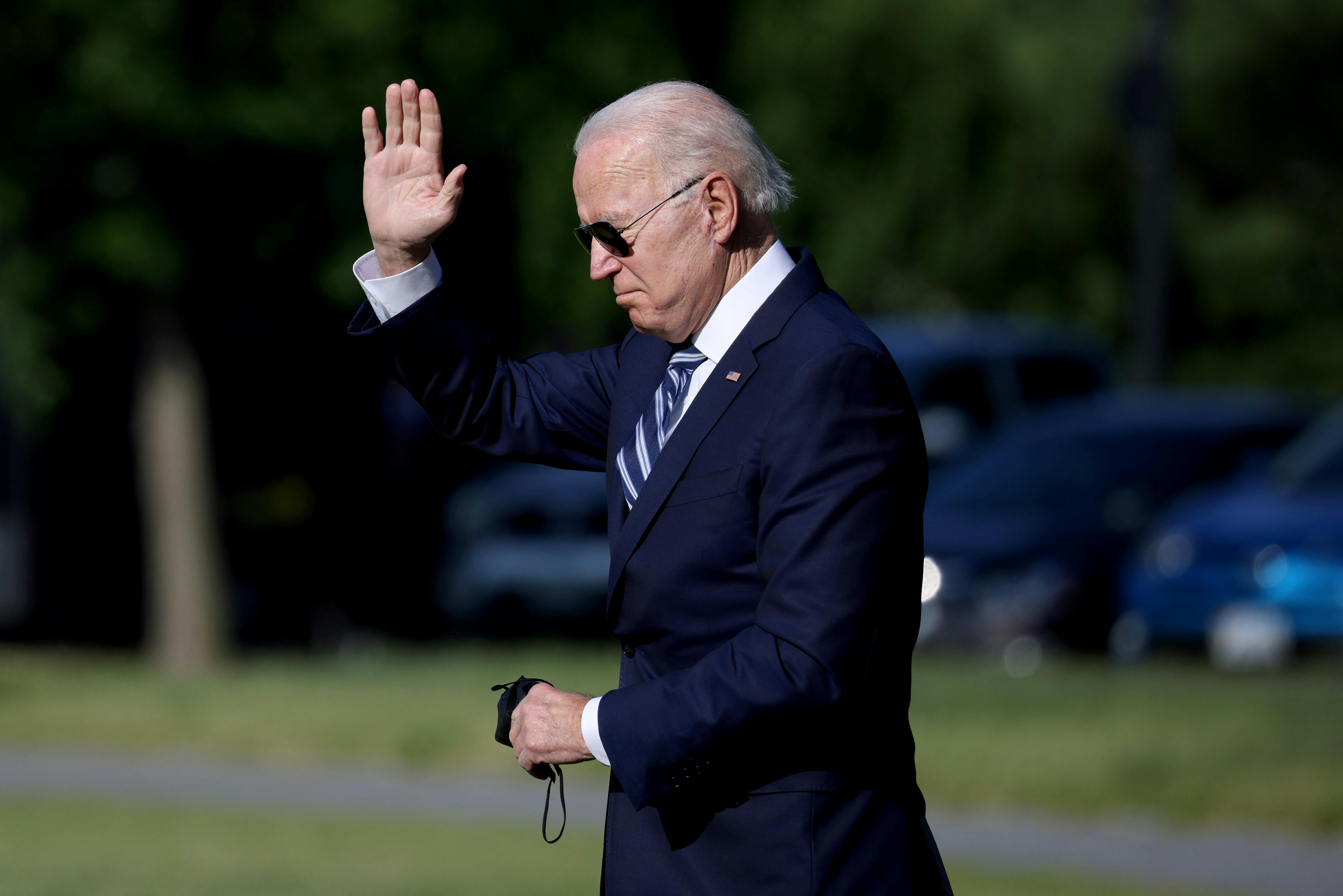 Joe Biden waves as he walks toward Marine One 