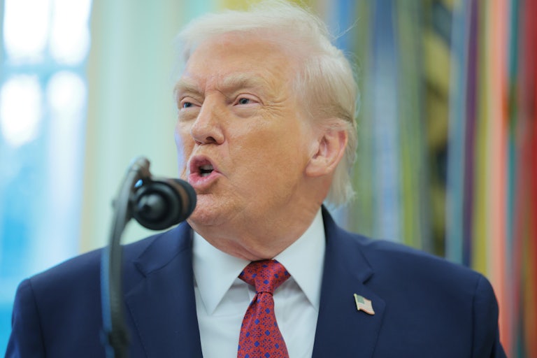 Donald Trump speaks into a microphone in the Oval Office