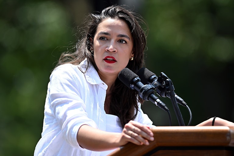 Representative Alexandria Ocasio-Cortez speaks at a lectern outside