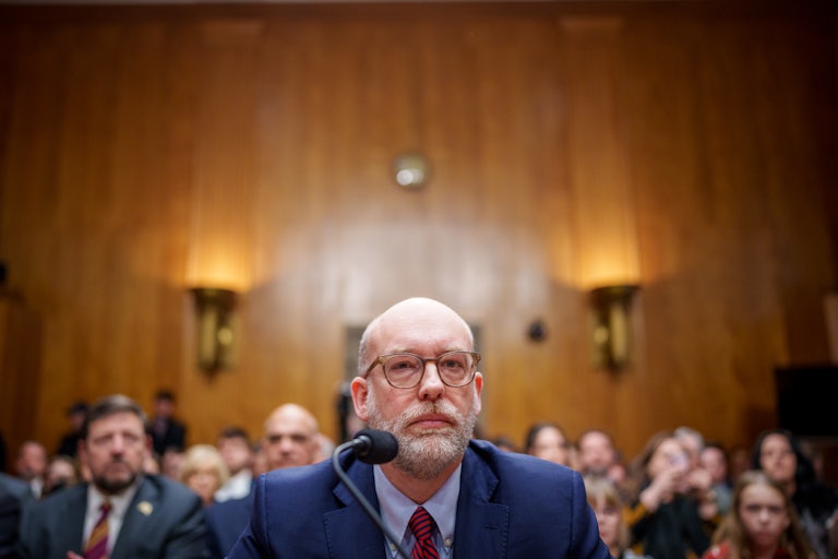 Russell Vought sits in front of a microphone during his Senate hearing