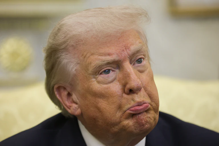 Donald Trump pouts while sitting in the Oval Office