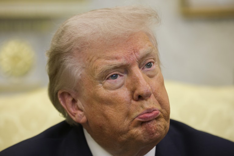 Donald Trump pouts while sitting in the Oval Office