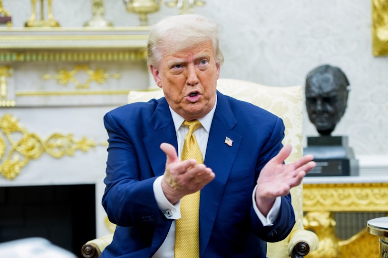 Donald Trump gestures while speaking and sitting in the Oval Office