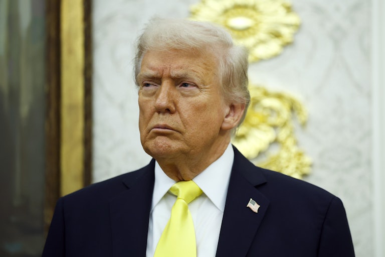 Donald Trump frowns while standing in the Oval Office of the White House.
