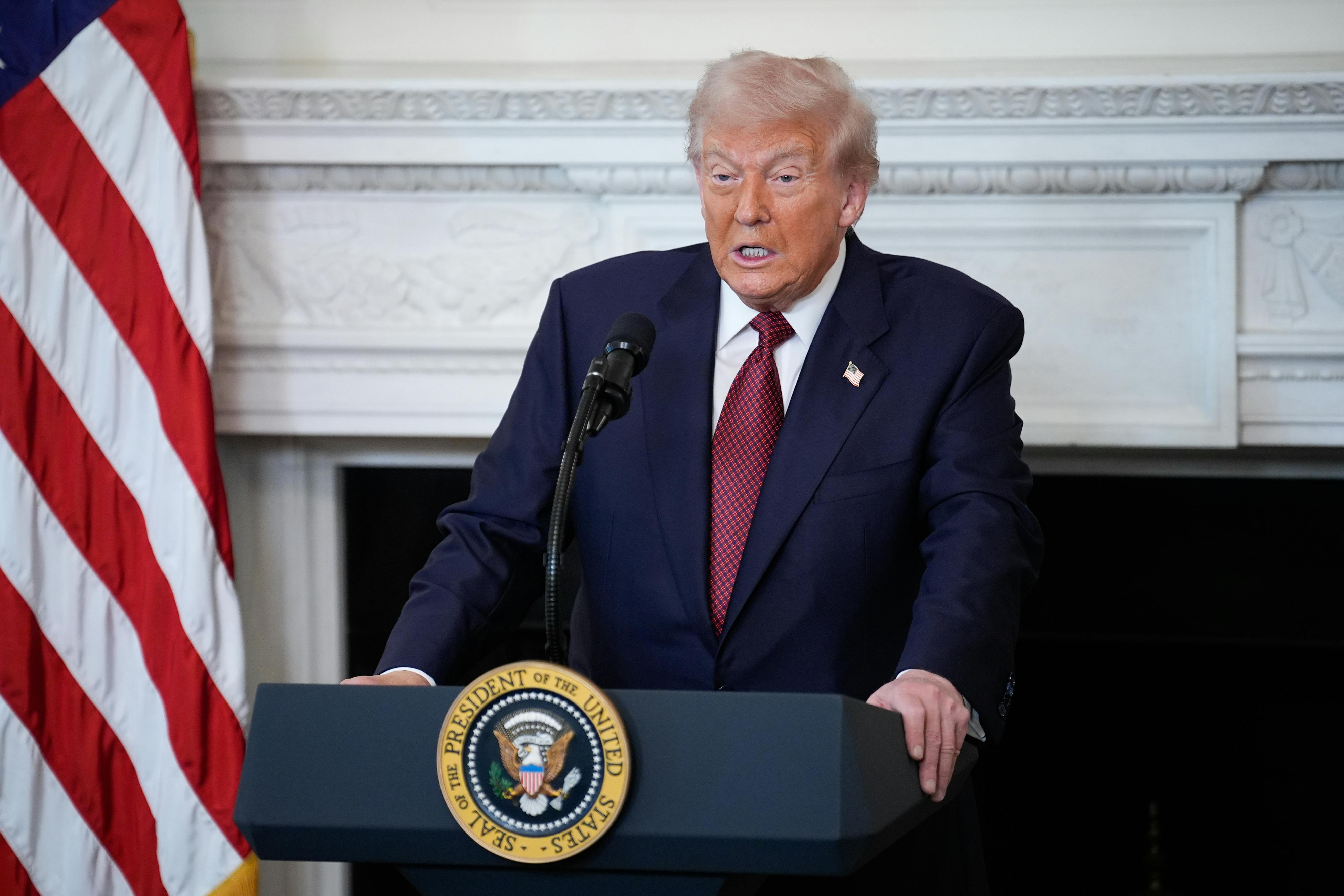 Donald Trump stands at a podium and speaks
