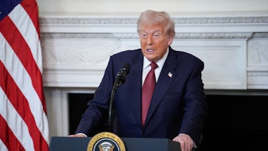 Donald Trump stands at a podium and speaks