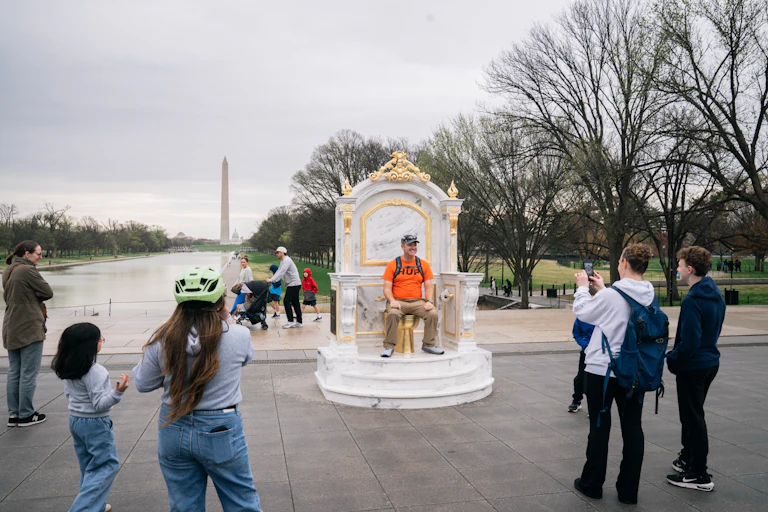 Someone sits on the golden toilet throne near the Reflecting Pool.