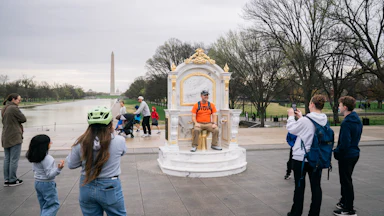 Someone sits on the golden toilet throne near the Reflecting Pool.