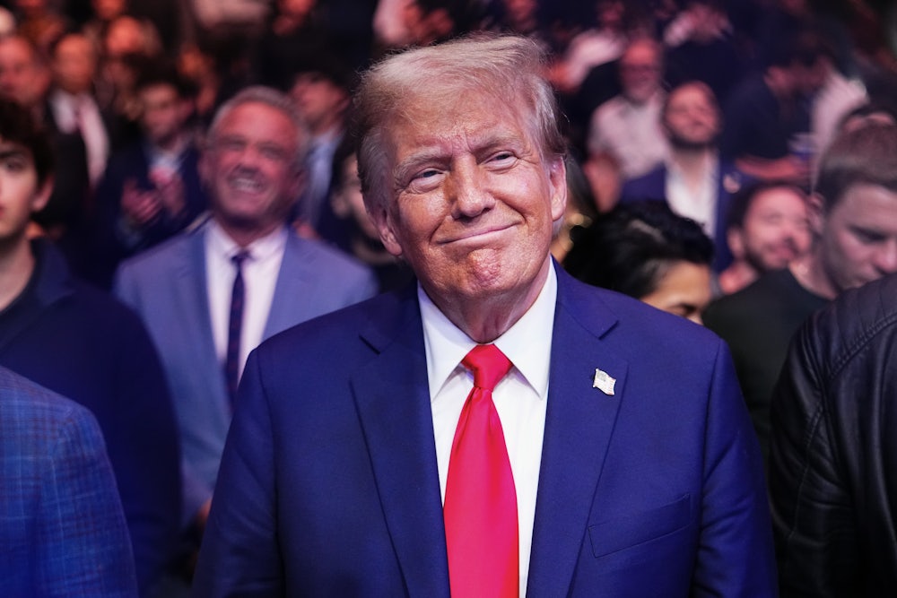 Trump smiles, with a crowd behind him.