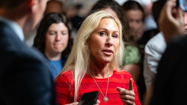Representative Marjorie Taylor Greene points while speaking to reporters in the Capitol.