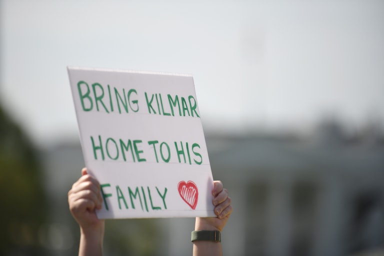 A person holds up a sign that says "Bring Kilmar home to his family"