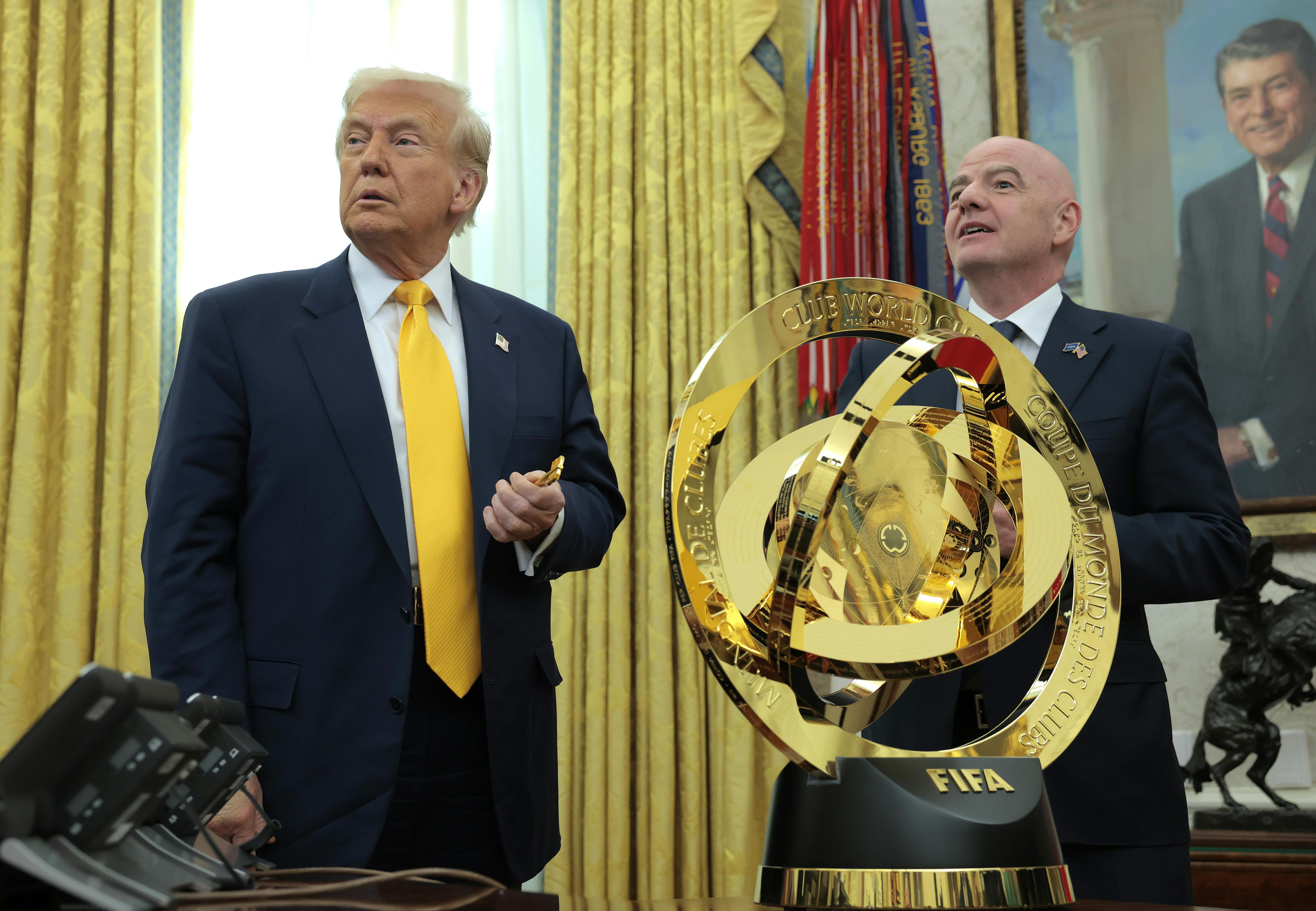 Donald Trump speaks alongside FIFA President Gianni Infantino after unveiling the 2025 Club World Cup trophy in the Oval Office at the White House.