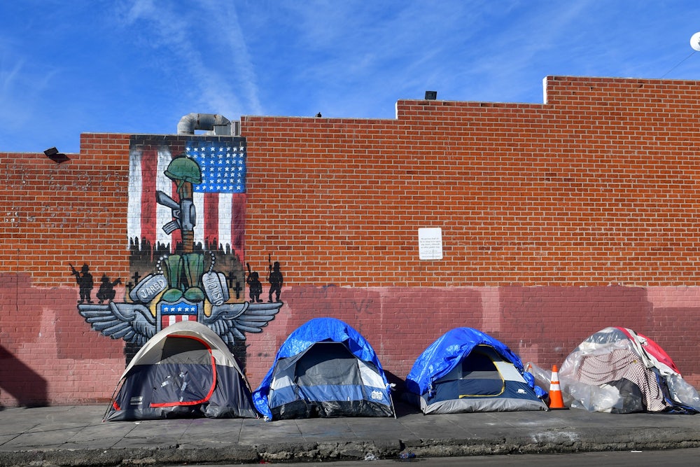 Tents for the homeless line a sidewalk in Los Angeles, California.